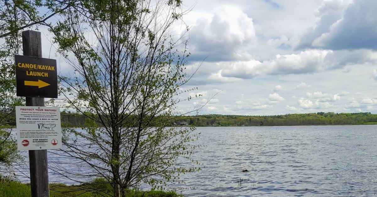 canoe and kayak launch sign next to lake