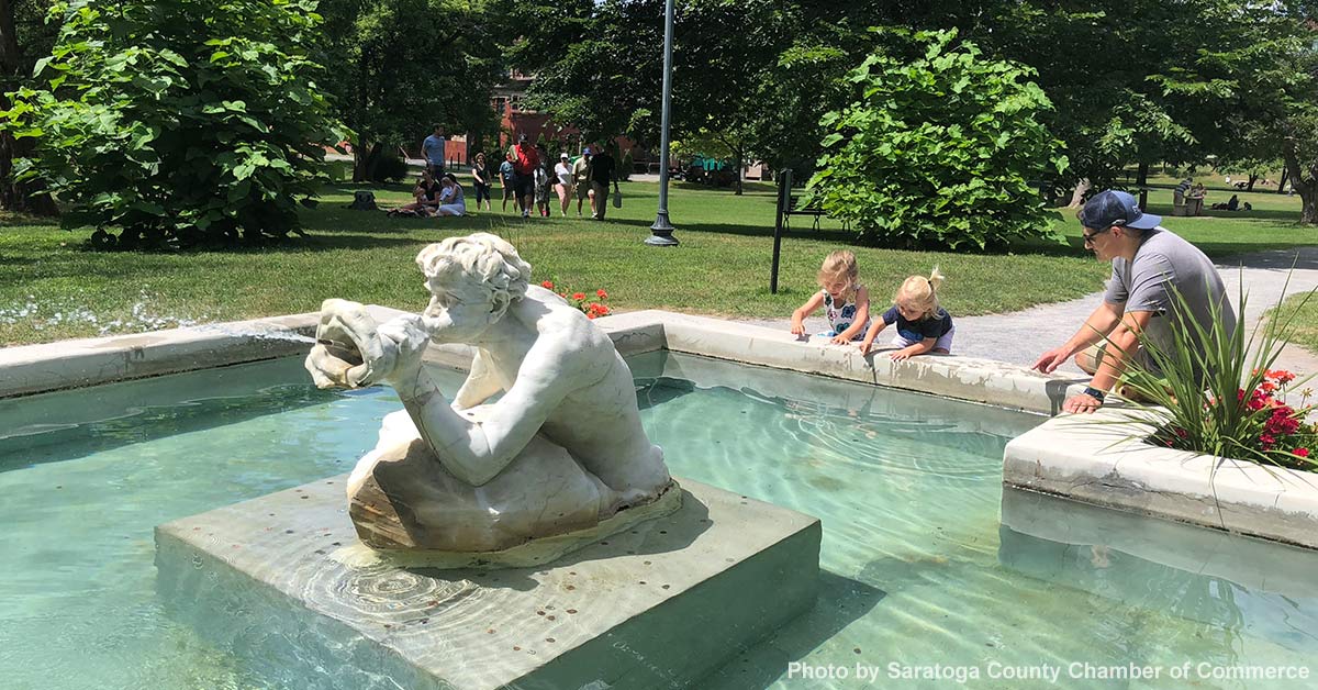 family in front of a fountain in saratoga's congress park