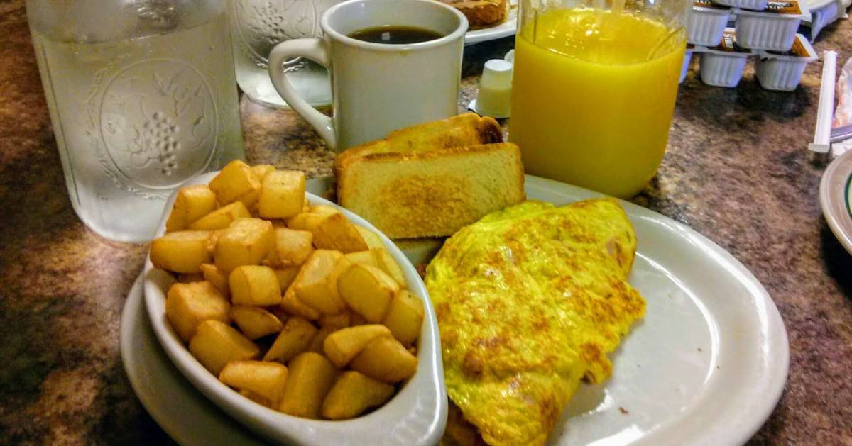 eggs, toast, potatoes, water, and coffee on a table