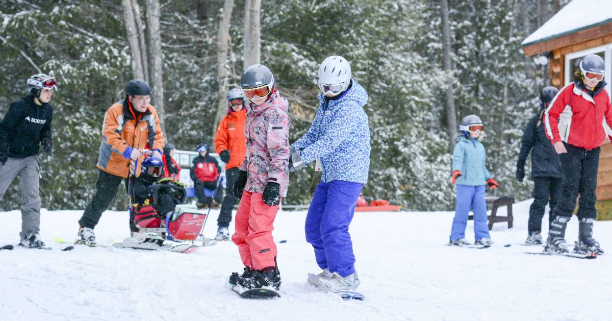 a kid learning how to snowboard at double h ranch