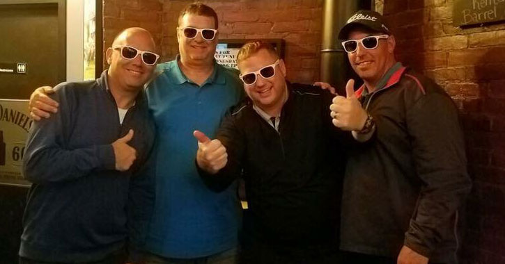 four guys in sunglasses posing together