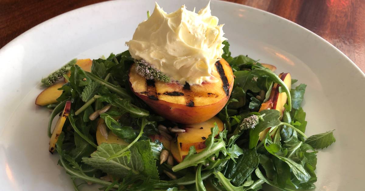 an arugula salad with peaches