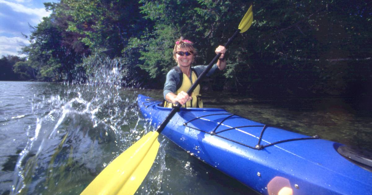 woman kayaking down a creek
