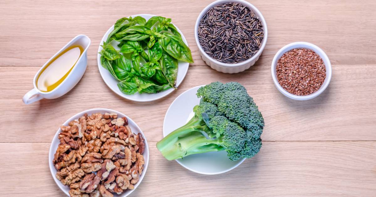 collection of plant-based foods on table like broccoli and walnuts