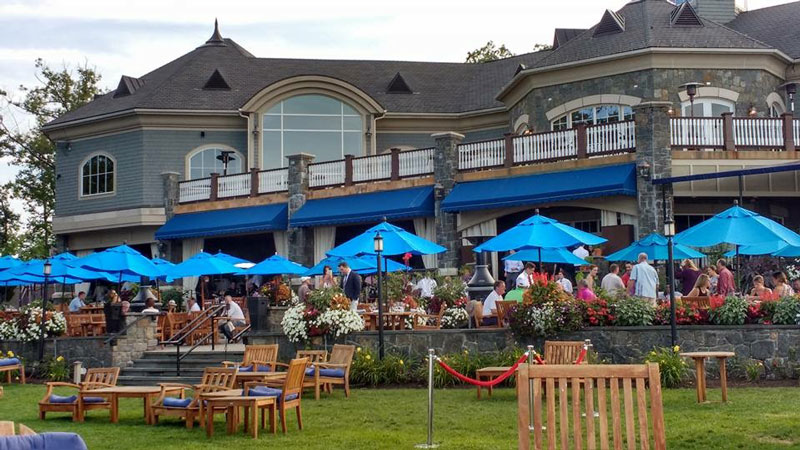 tables with light blue umbrellas on the patio at prime