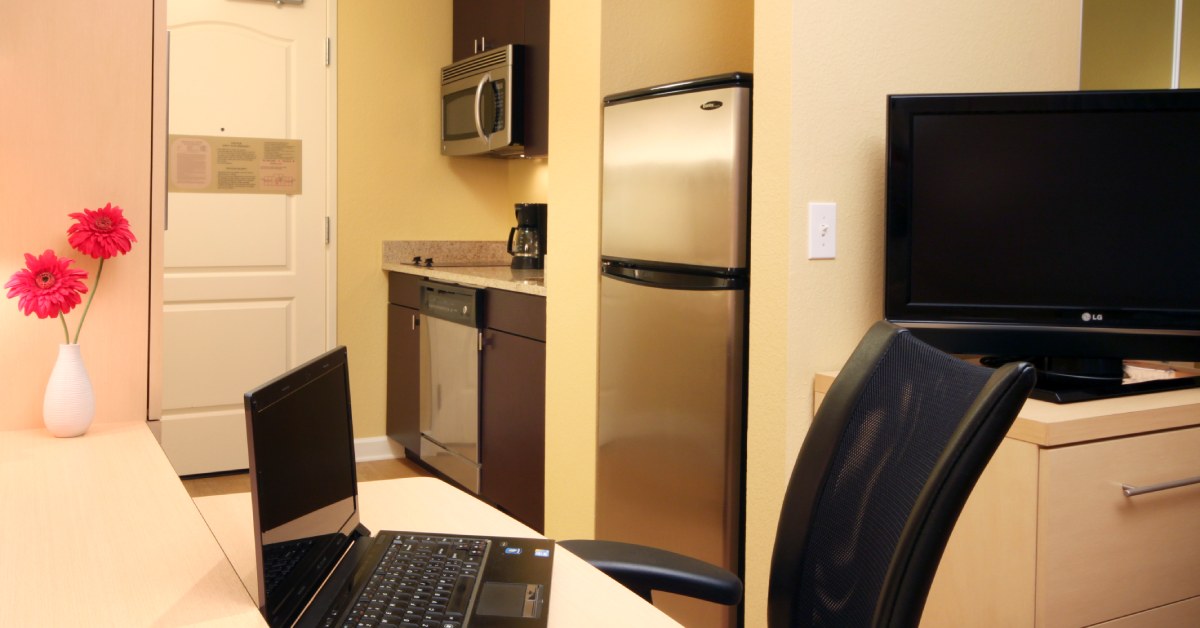 hotel suite with work desk and kitchen area