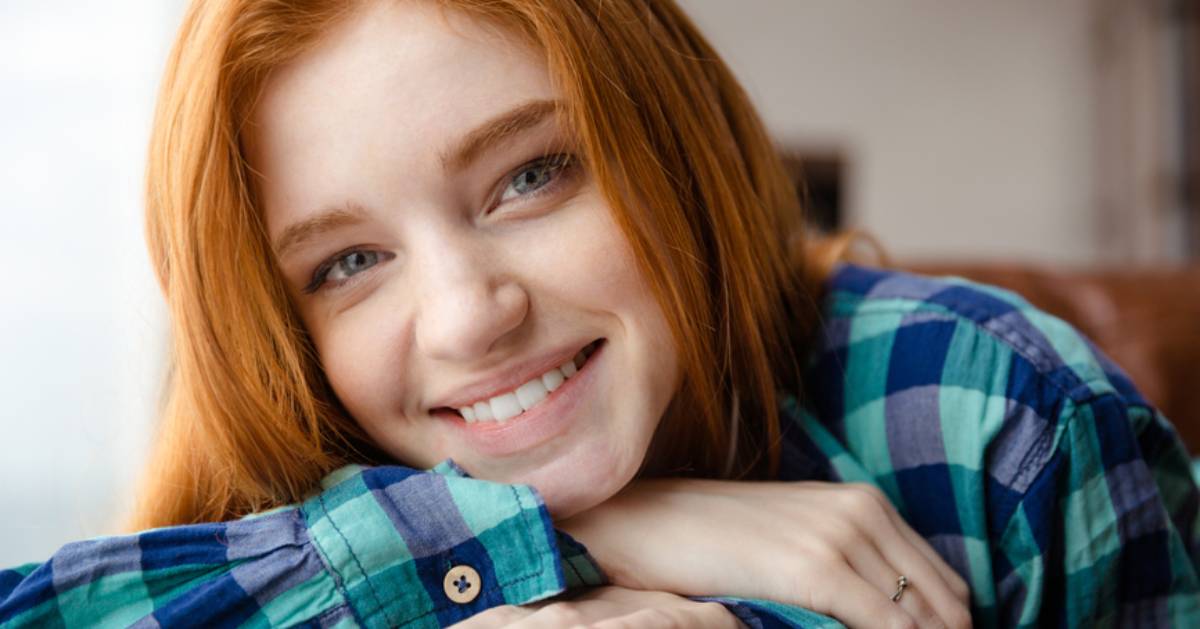 woman smiling and wearing a blue plaid shirt