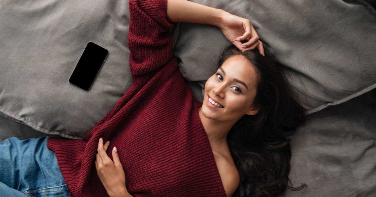 woman lying down with red asymmetrical shirt