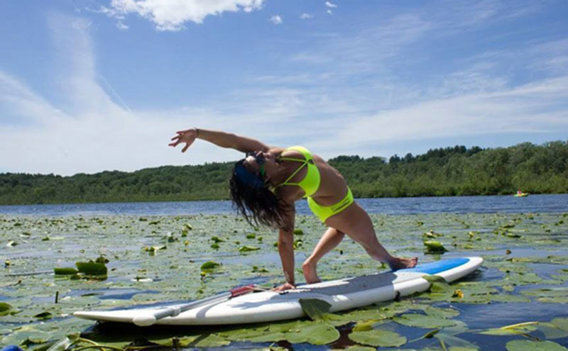 Woman doing yoga on a stand up paddleboard