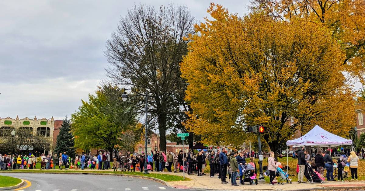 crowd/line for trick or treating at fall festival in city