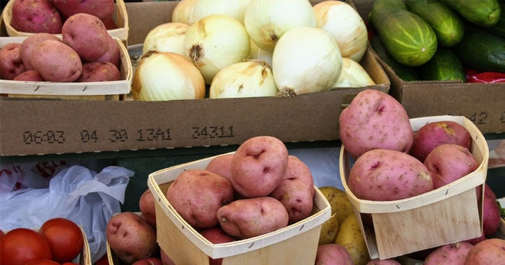 potatoes, onions, and other vegetables on display