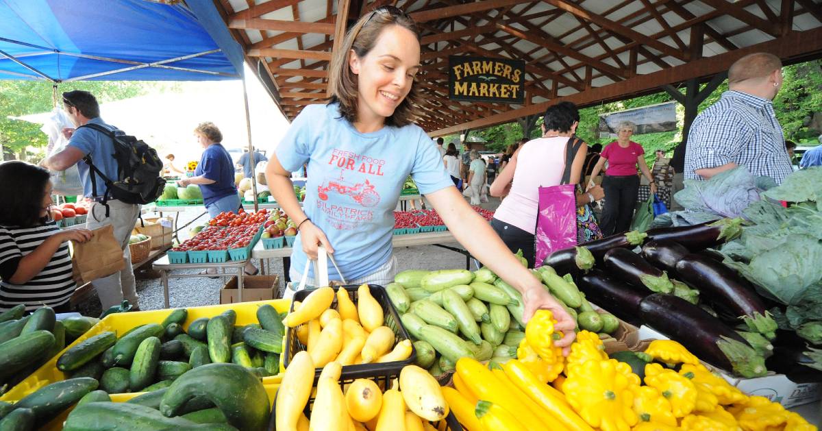 smiling girl at farmers market packing food