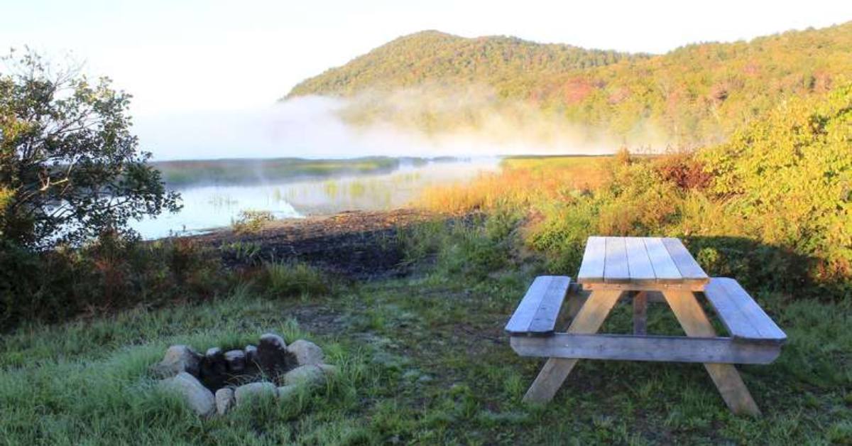 picnic table in front of a lake and mountain
