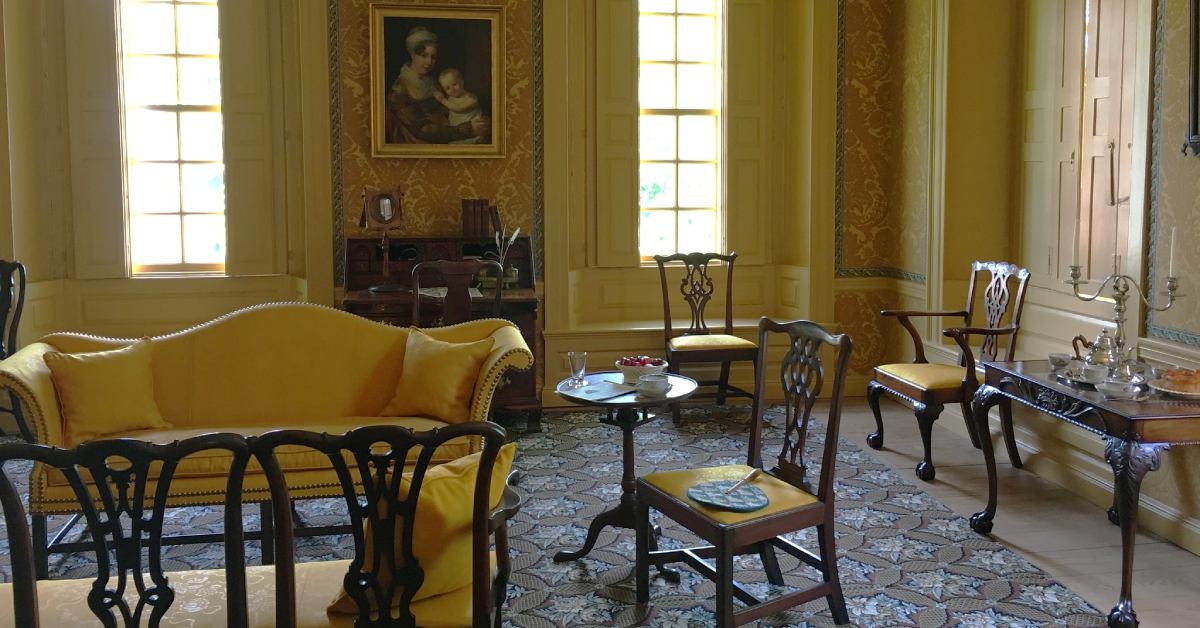 a room with antique furniture and yellow walls