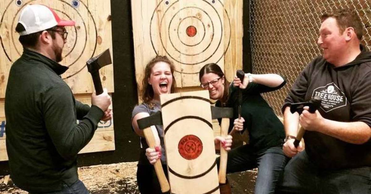 people holding axes and a target smiling 