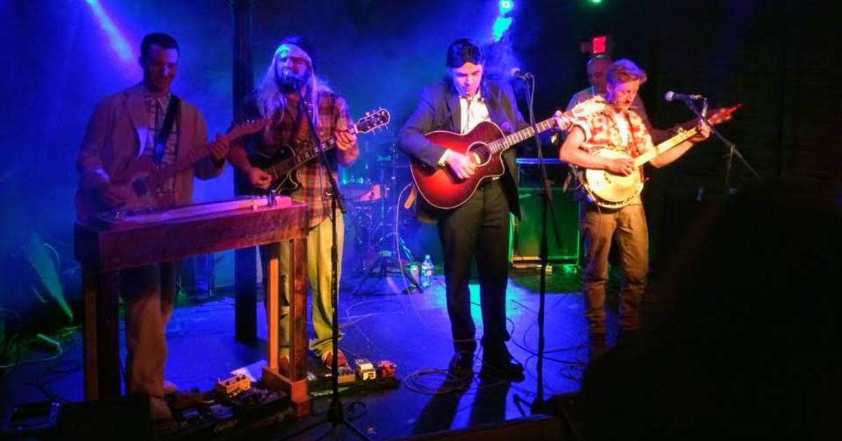 four people on stage singing