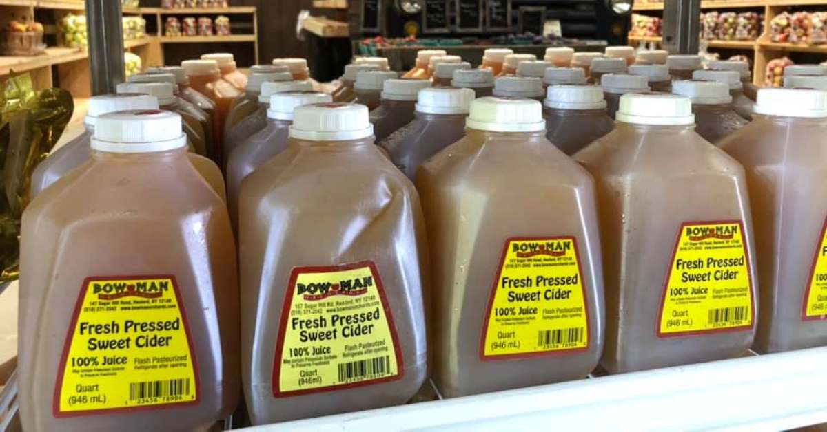 gallons of fresh pressed sweet cider on a rack