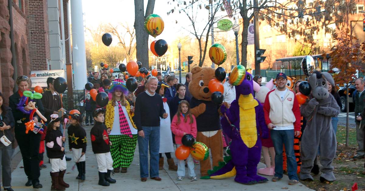 people dressed in Halloween costumes on sidewalk