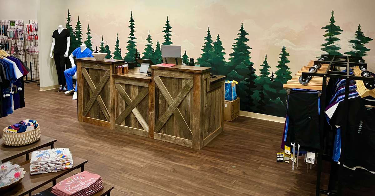 a checkout area with rustic wooden accents and a painted treeline accent wall