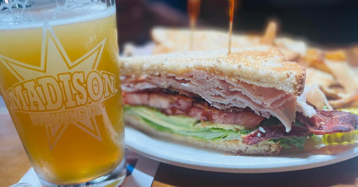 a glass of beer next to a sandwich