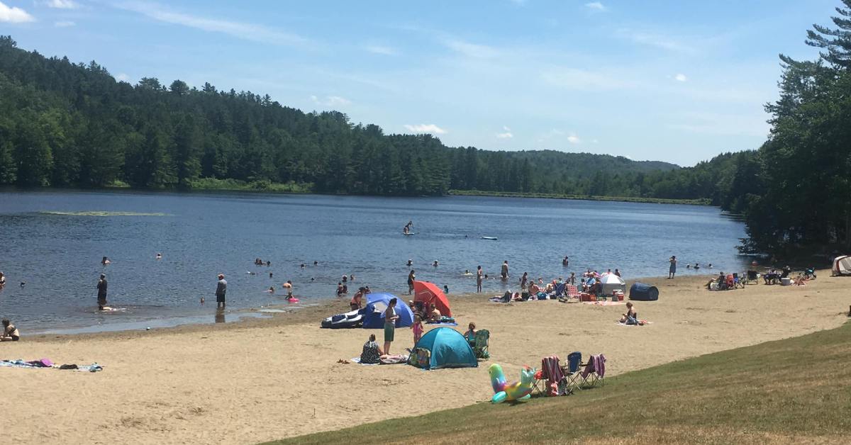 beach at cherry plain state park during summer with people swimming and lying on the sand