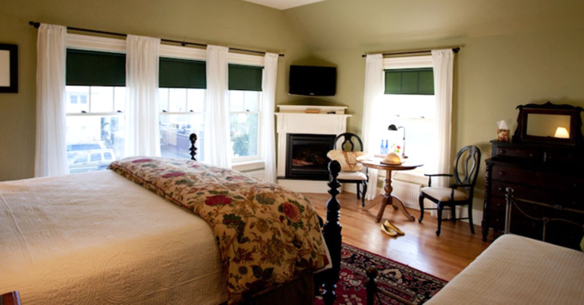 bed and breakfast guest room with four windows, and bed, and a fireplace