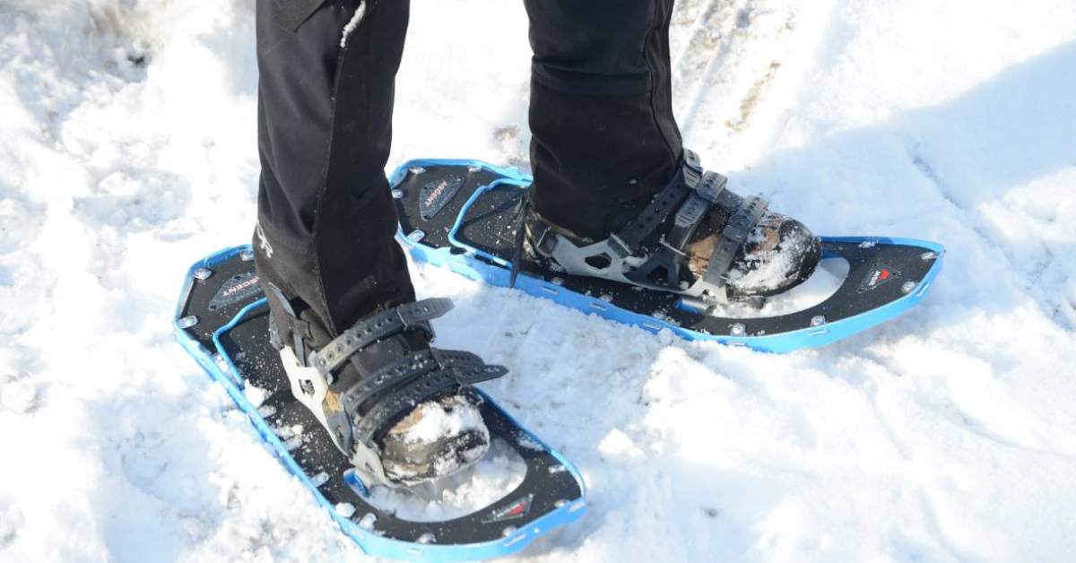a person wearing black and blue snowshoes