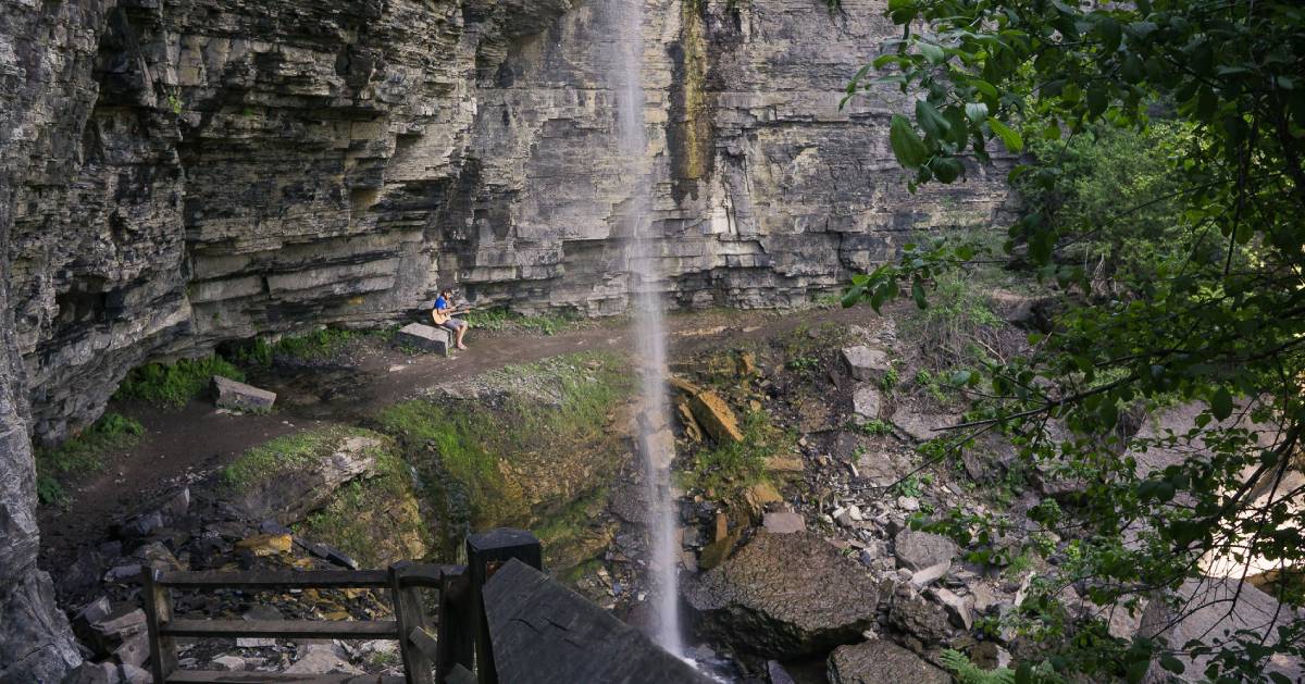 person by small waterfall on hike