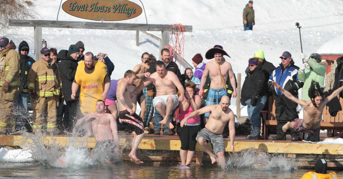 people diving into a lake for a polar plunge