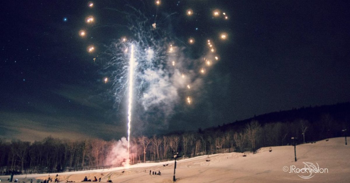 fireworks over a snowy mountain at night
