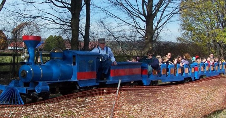 a blue train with people riding