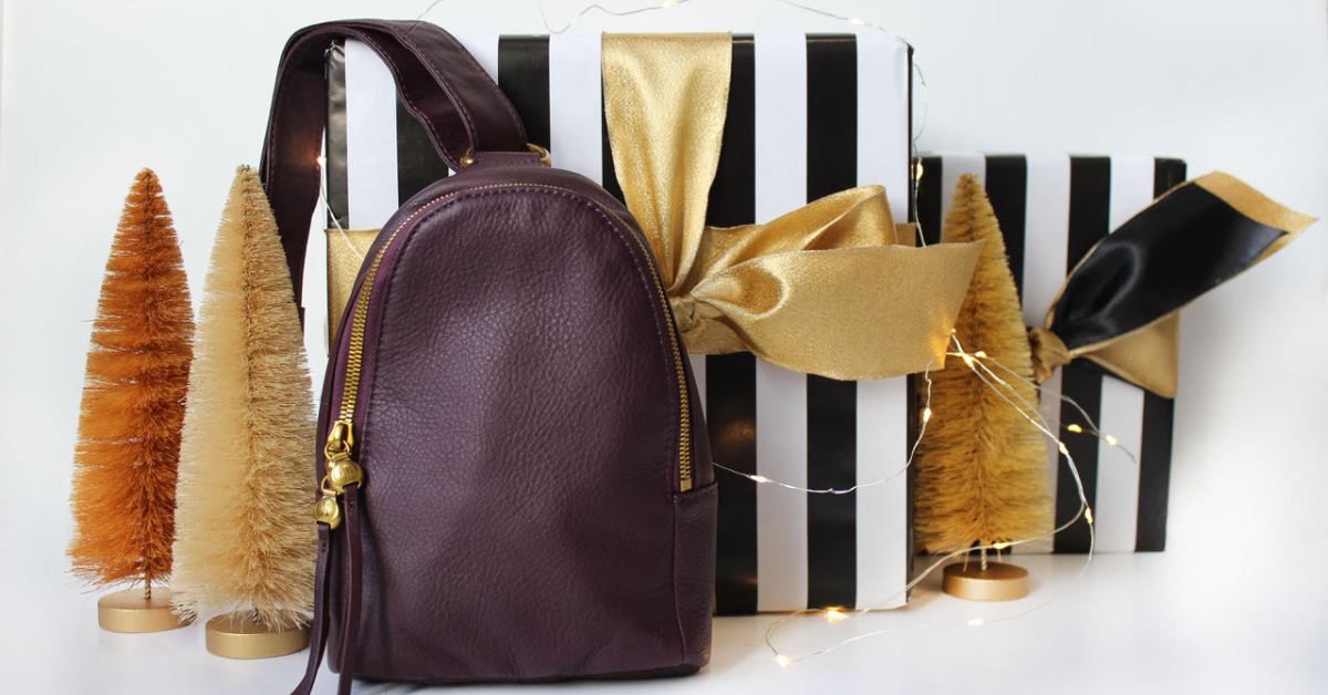 little holiday tree decor, lights, and a purple leather bag on display