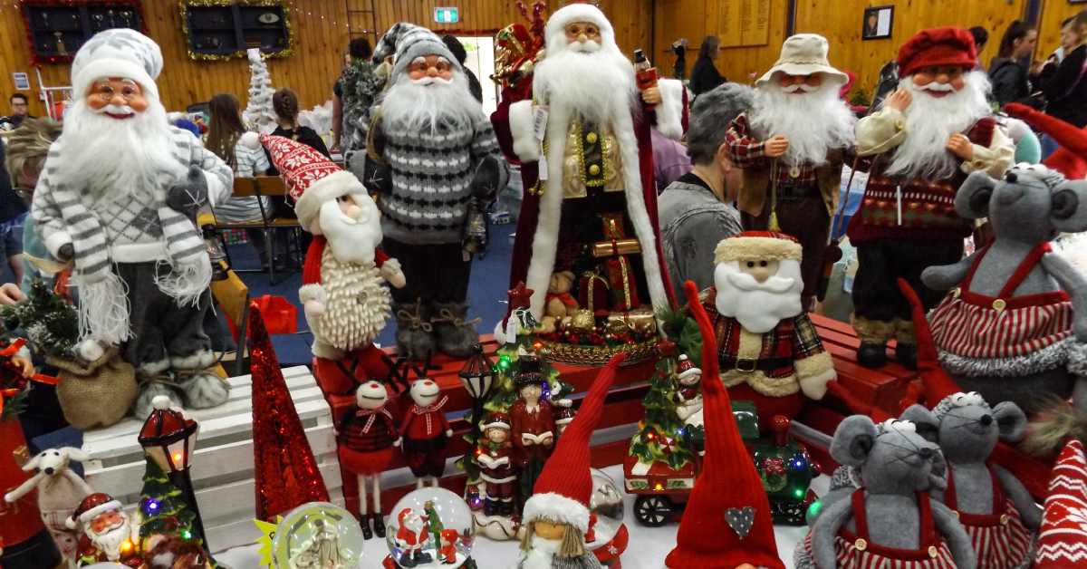 craft fair table with santas and christmas decorations on it