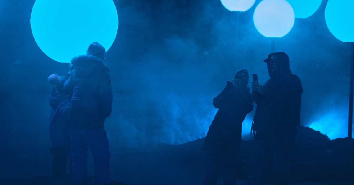 people standing near glowing blue orbs