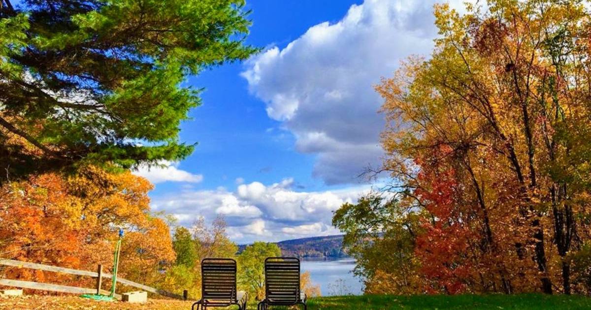 view of chairs by lake in the fall