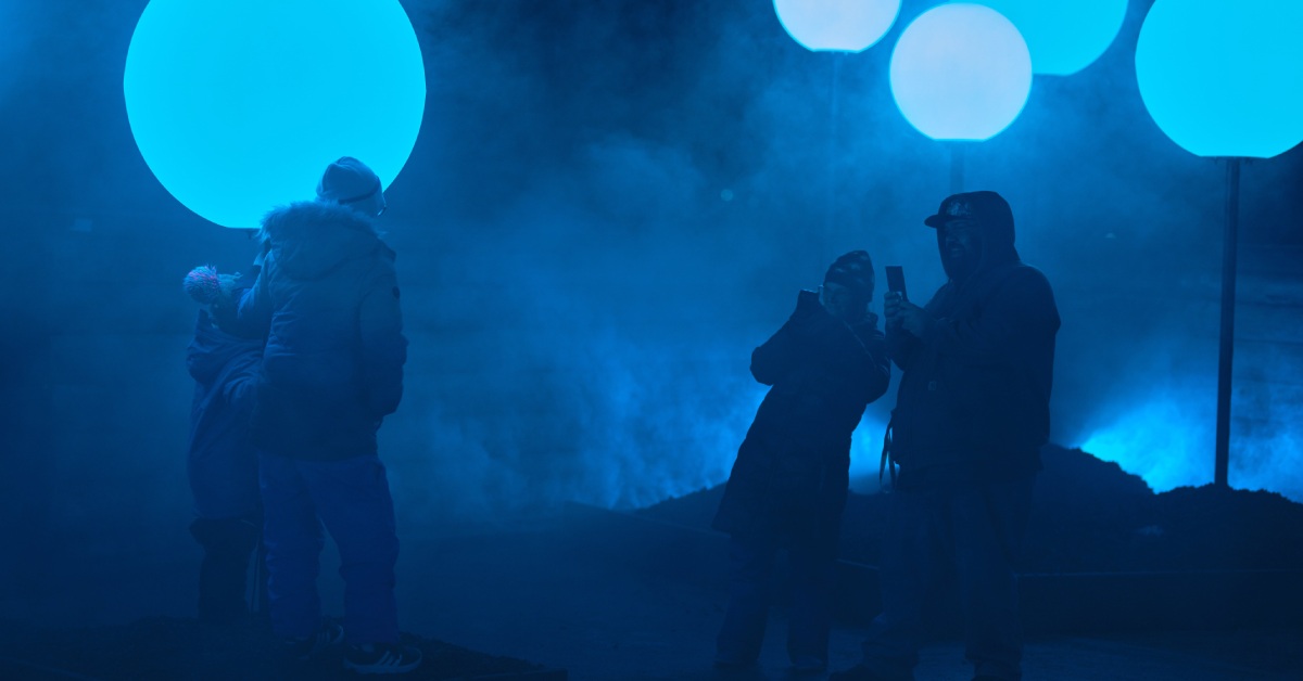 four people standing by glowing blue orbs