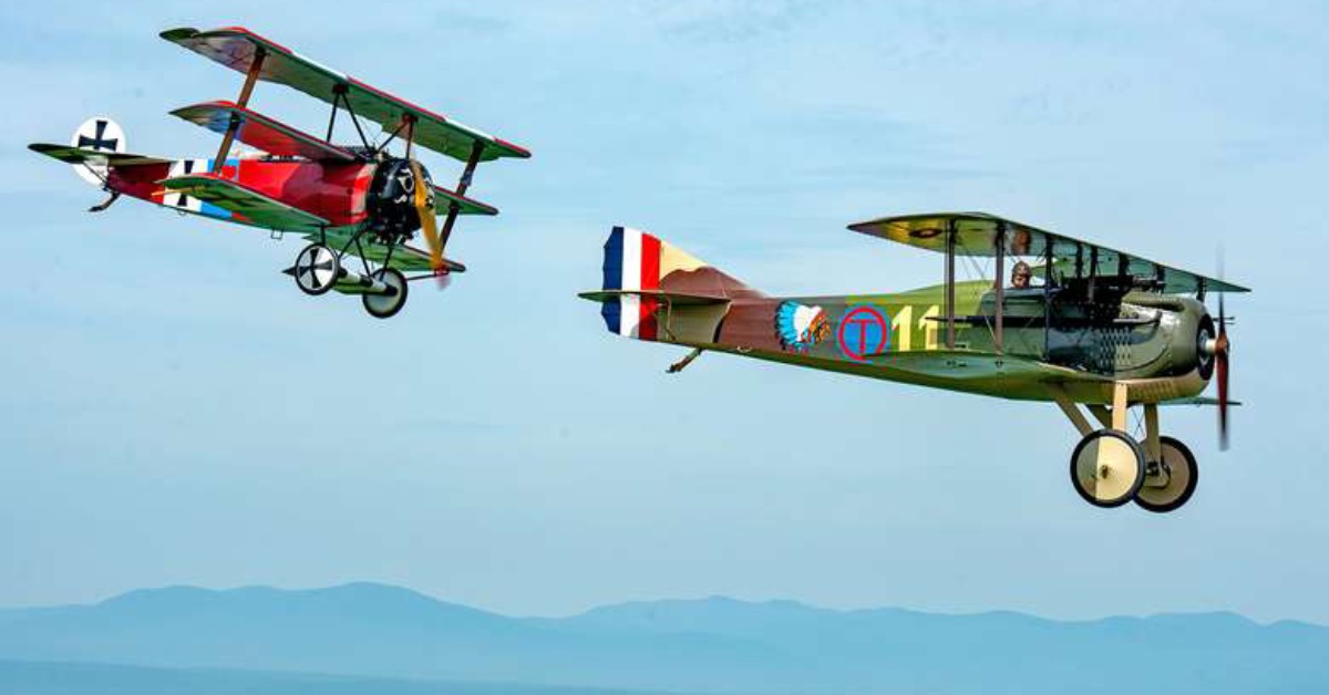 a pair of biplanes flying in the sky