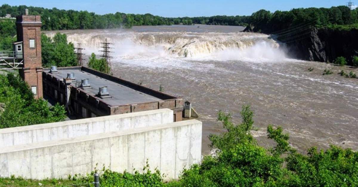 waterfall on a river with a powerplant next to it