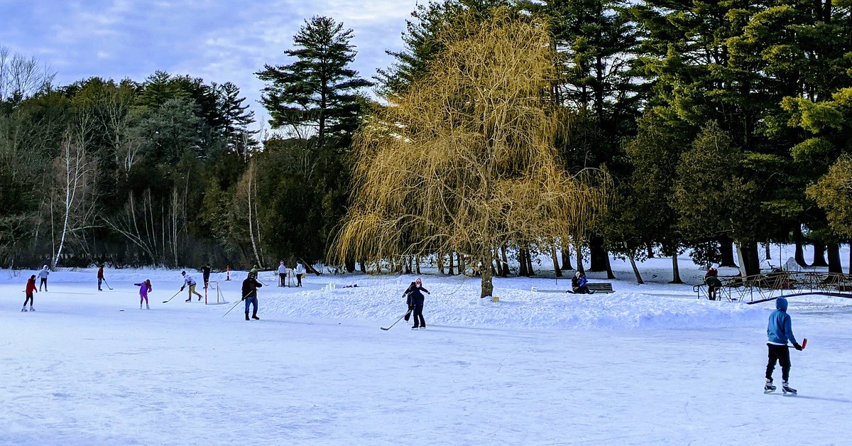 kids skating and playing hockey on a pond