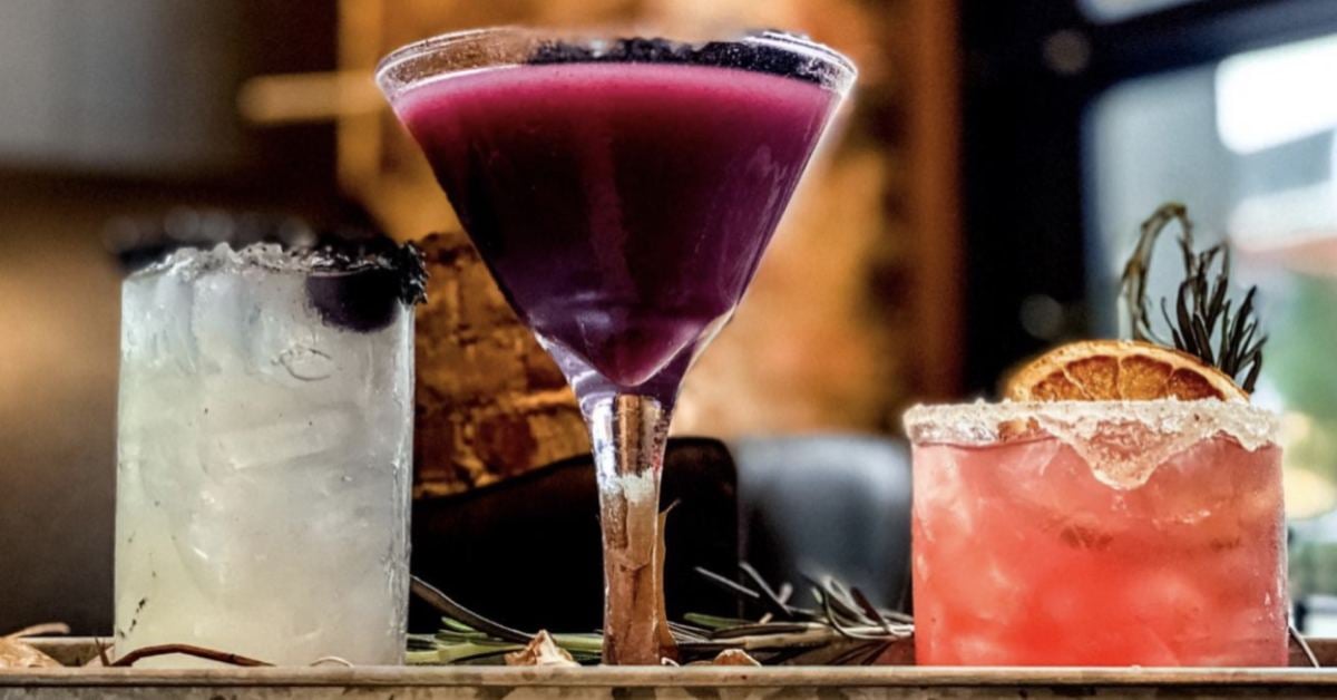 three colorful cocktails on a bar
