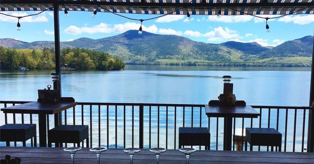 restaurant patio overlooking a lake with mountains in the background