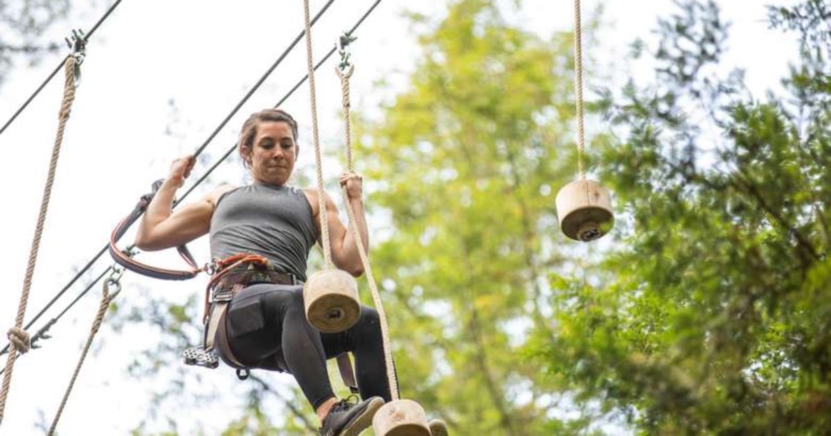 woman in the air on a high ropes course