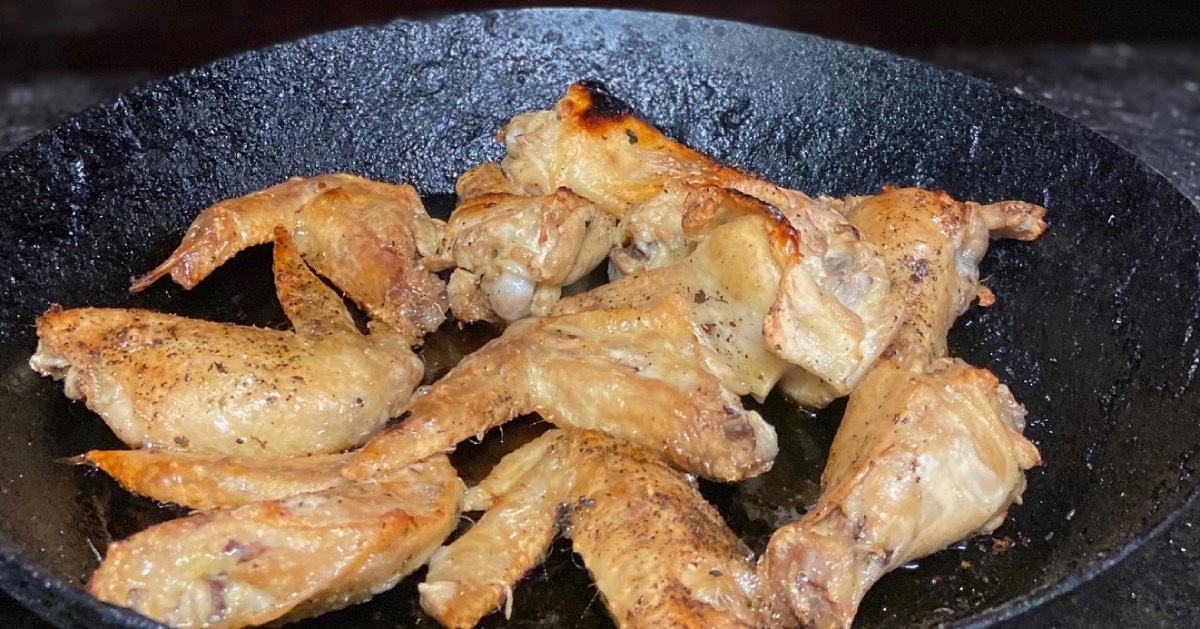 chicken wings being cooked in a wok