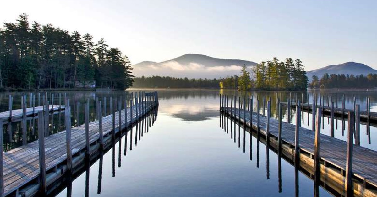 two docks going out on a lake with mountains in the background