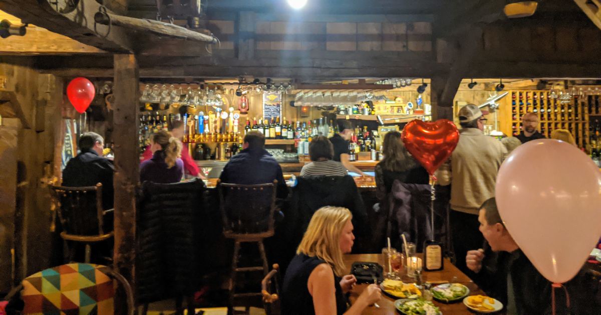 people in bar in restaurant, wood panel walls
