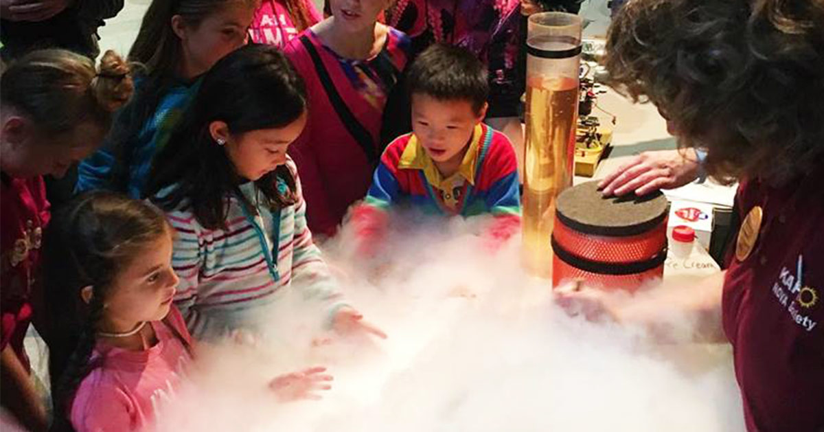 kids watching a science experiment at a museum