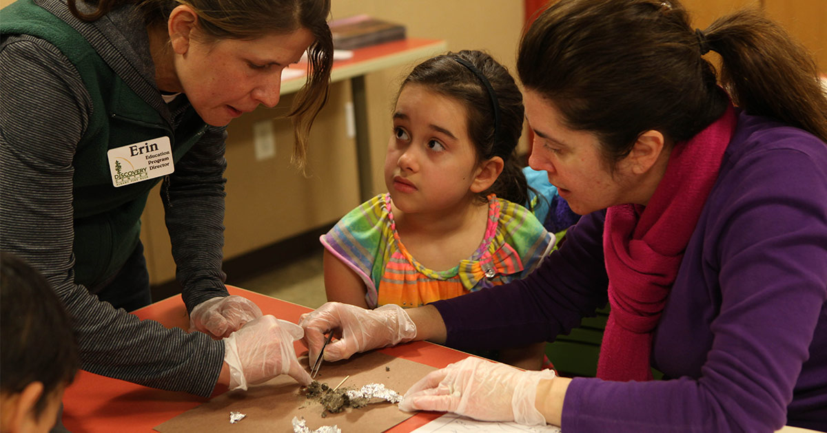 girl participating in an owl pellet lesson taught by an educator