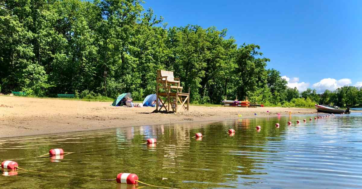 beach on a lake with a lifeguard stand