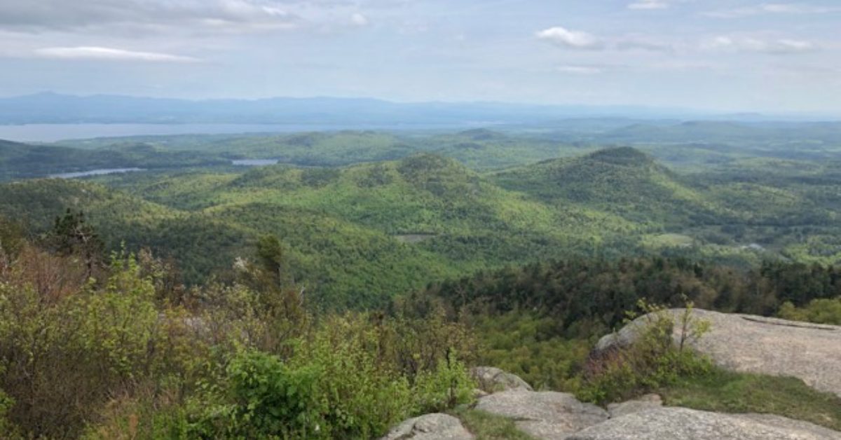 view of green mountains and a lake in the distance