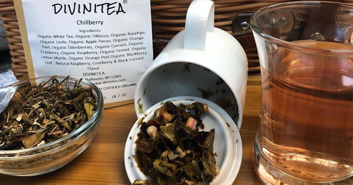 bag, cup, dish, and glass of tea, bag says Divinitea and lists ingredients